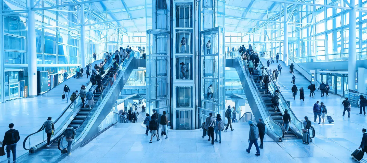 Busy transit hall with escalators and wayfinding
