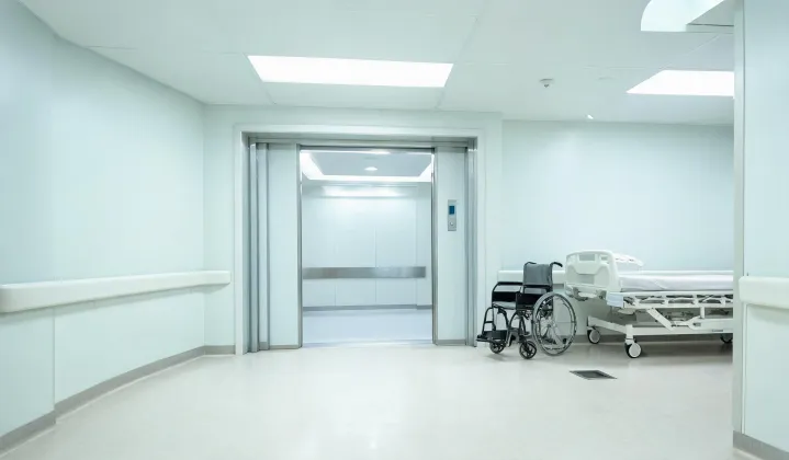 Hospital corridor with wide bed elevator doors open